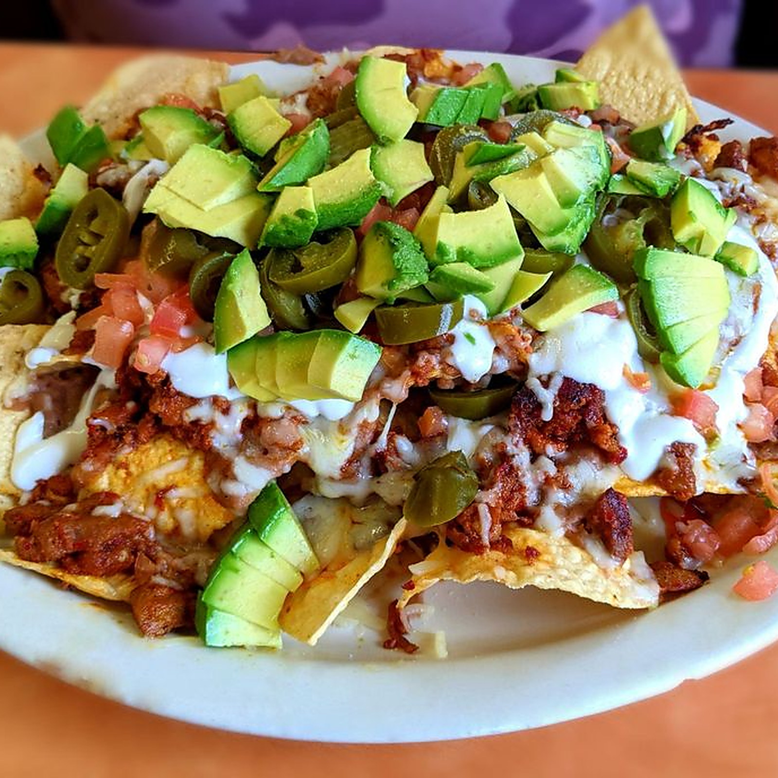 NACHOS &mdash; Avocado, jalape&ntilde;os and crema over chips