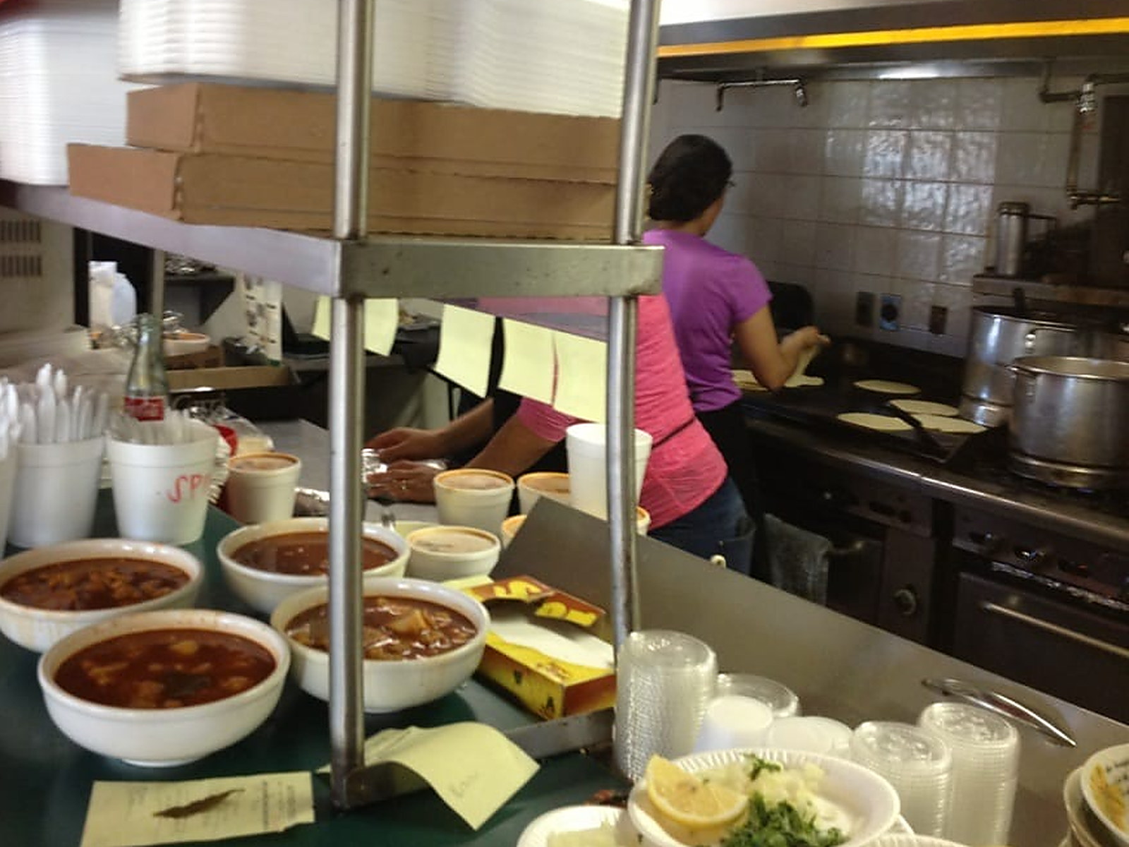 Bowls up on the pass and tortillas on the griddle, seen from the counter